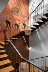 Handcrafted cane pendant lights gracefully descend from the skylight, adding warmth and a touch of rustic elegance to the stairwell.