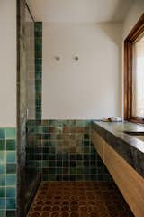 Brazilina soap stone countertop, zellige wall tiles and belgian terracotta blend in the deeply warm and textured bathroom