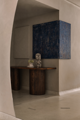 The entrance displays a work of art by Chennai-based mixed media artist Suresh Kumar. The curvilinear wall blurs sightlines, conjuring the illusion of a larger volume. The console is by Workers of Art in collaboration with Formave. The decor is from Wudapple.