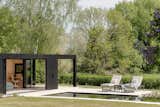 Bi-folding doors open out to relaxation areas next to the swimming pond.