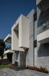 Clean horizontal layers in concrete; floating roof plane creates a sheltered transitional space.