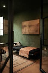 Moody office with dark green plaster walls using Meoded Tintoretto. Cleopatra' Daybed by Auping.