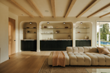 Media and family room. Plaster walls, custom stained oak built ins, marble countertops, custom glass shelves with brass frames and white oak wood beams. 