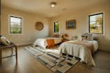 Guest bedroom staged as a kids bedroom featuring plastered walls and a handmade ceiling sconce. 