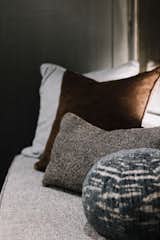 Custom pillows bring in comfort while adding to the moody and masculine feel of this space.