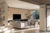 A warm and inviting modern living space with natural light, earthy tones, and a seamless indoor-outdoor connection. The combination of wood, metal, and soft furnishings creates a cozy yet sophisticated ambiance.