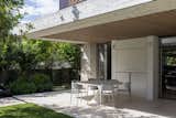 A stylish outdoor dining area seamlessly integrated with nature, featuring minimalist design.