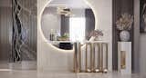 This elegant console table setup is a masterpiece of modern luxury interior design, blending bold metallic details with soft ambient lighting for a stunning visual impact. The standout feature is the large circular backlit mirror, which not only adds depth to the space but also creates a warm and inviting glow.

The sculptural gold console table with a marble top offers both style and functionality, serving as the perfect place for decorative accents, fresh florals, and fine glassware. To the right, a minimalist plinth-style pedestal topped with a ceramic vase and dried arrangements adds a touch of organic elegance.

Rich textures, a metallic room divider, and soft neutral tones throughout the space emphasize a balance of contemporary glamour and timeless sophistication. Ideal for entryways, dining room corners, or transitional spaces, this design reflects the best in high-end interior styling.
