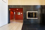 The black sheet steel surround for the wood-burning stove contrasts the red paint and wood materials of the rest of the home.