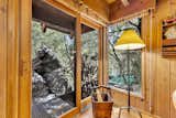 Forest views and natural stone are visible from nearly every corner, with a large boulder just outside the living room—one of many ways the home embraces the landscape.