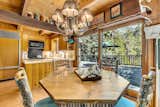 A cozy dining nook opens to the expansive deck, inviting seamless indoor-outdoor living with views of the surrounding forest and mountain ridgelines.