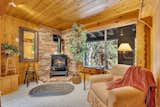 A cozy sitting nook in the primary bedroom invites quiet mornings by the fire and peaceful views of the forest just outside your window.