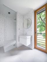 A light-filled bathroom with minimalist white tiles and elements, offering a serene and modern aesthetic.