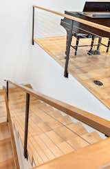 Detail of stairs to main living space - local and sustainably sourced hardwood floors and railing, custom fabricated stair rails