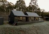 “We didn’t want anything flashy. Just something that belonged here,” Andrew says. The cabin’s gabled form is preserved and reclad in black Colorbond steel blends into the surrounding bushland.