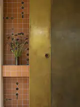After: A circular motif inspired by the seedpod of the native kōwhai tree appears throughout the kitchen in stained glass, tile, and brass details.