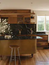 After: Solid walnut cabinetry sits comfortably beside the home’s original matai floors, reconnecting the kitchen to the house’s 1940s character.
