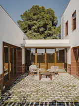  The courtyard improves cross ventilation, captures natural light, and creates a thermal buffer between the two wings.
