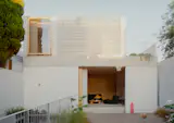Olaver Architecture ran a two-storey studio across the back of the block and set the pool in the gap between it and the main house. Recycled white brick, a concrete band beam, and a wall of glass block face the garden. Angelucci butterfly chairs sit poolside. "It was really important that it be a beautiful object in the backyard," Olaver says.