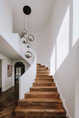 New curved entry staircase balustrade softens the existing architecture of the home, herringbone engineered timber floor boards enhance the sophisticated concept. 