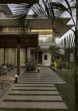 Large sliding glass doors create a visual and functional connection, allowing natural light to flood the interior spaces while providing direct access to the shaded verandah. The transition feels effortless, promoting cross-ventilation and a sense of openness.