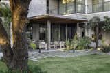 The heart of the home, the living room, extends gracefully into the garden through a shaded verandah, blurring the boundaries between indoor and outdoor living. 