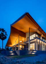 Under an overarching roof, the sheltering ensemble includes a stone shophouse, a small brick utility barn, and an open pavilion, on a stone plinth.