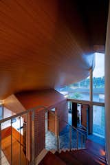 The micro brick house of a utility barn is tucked underneath the gigantic roof plane.