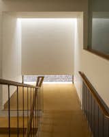 Staircase mid-landing beneath a skylight’s embrace