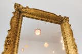 The antique mirror captures the reflection of the sculptural light installation