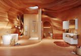A luxurious, cave-inspired bathroom featuring smooth, sculpted walls in warm terracotta tones. The freestanding white bathtub is placed on a slightly elevated platform, accompanied by a small wooden stool with bath essentials and magazines. To the right, a frameless glass walk-in shower with chrome fixtures sits adjacent to a recessed toilet alcove. On the far right, a floating vanity with clean white cabinetry, an integrated sink, and a mirrored cabinet adds a modern touch. The space is softly illuminated by natural light from a skylight above and subtle ambient lighting throughout, creating a serene, spa-like atmosphere.