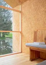 A floor-to-ceiling window looks out over a pond.