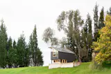 Inside the small, open-plan cabin, different programmatic zones—like the  kitchen, living area, and bedroom—are defined by level changes.