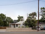 Viewed from the street, the studio’s simple gable form and corrugated siding echo the modest mid-century homes of Montopolis. A low concrete planter defines the edge of the property, providing privacy while maintaining an open connection to the neighborhood.