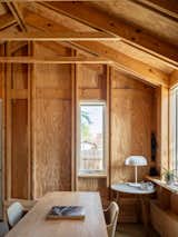 Exposed stud walls and roof framing give the interior a sense of clarity and craft. The straightforward detailing turns common construction materials into the primary finish, echoing the studio’s philosophy of honest expression.