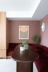 Tucked into a sunlit corner off the kitchen, the custom banquette pairs maroon velvet upholstery with a cozy, built-in feel. A thatched-texture wallpaper wraps the back wall, adding depth and warmth, while sculptural RBW sconces in organic forms create a soft, layered glow. Overlooking both the kitchen and the river, it’s a daily gathering spot for slow breakfasts and quiet moments.