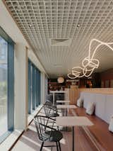 A snaking 'loose thread' ceiling light from UR-EKA contrasts with the scheme's strict geometries