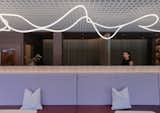 A banquette in vertical grain timber laminate runs the length of the lounge with the 'loose thread' lighting above