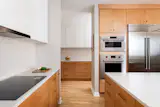A scullery connects directly to the kitchen, creating seamless circulation that supports both cooking and gathering. Recessed lighting and concealed receptacles allow for a continuous wall texture, letting the material’s texture resonate quietly throughout the space.