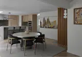 View from the living space toward the remodeled dining and kitchen, with the original dividing walls removed to create an open plan. A vertical rotating wood screen subtly marks the edge of the dining room while maintaining visual flow.